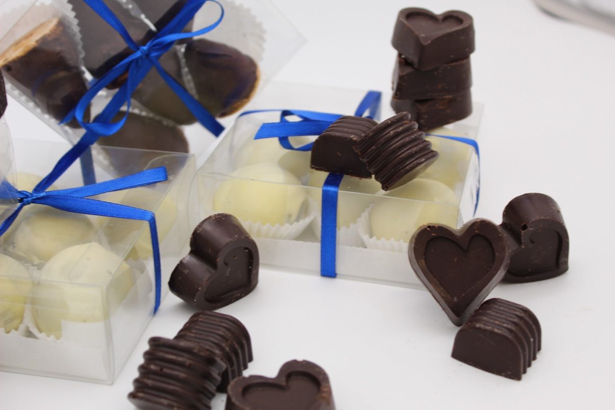 Cioccoland gift boxes of heart bonbons and white truffles tied with royal blue ribbons