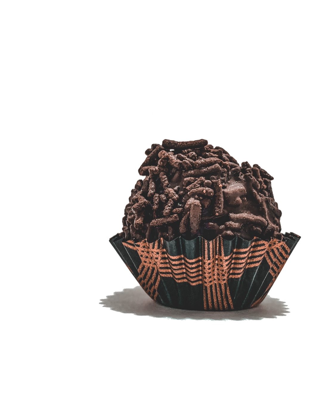 A Cioccoland truffle rolled in chocolate sprinkles, in a green and gold cup